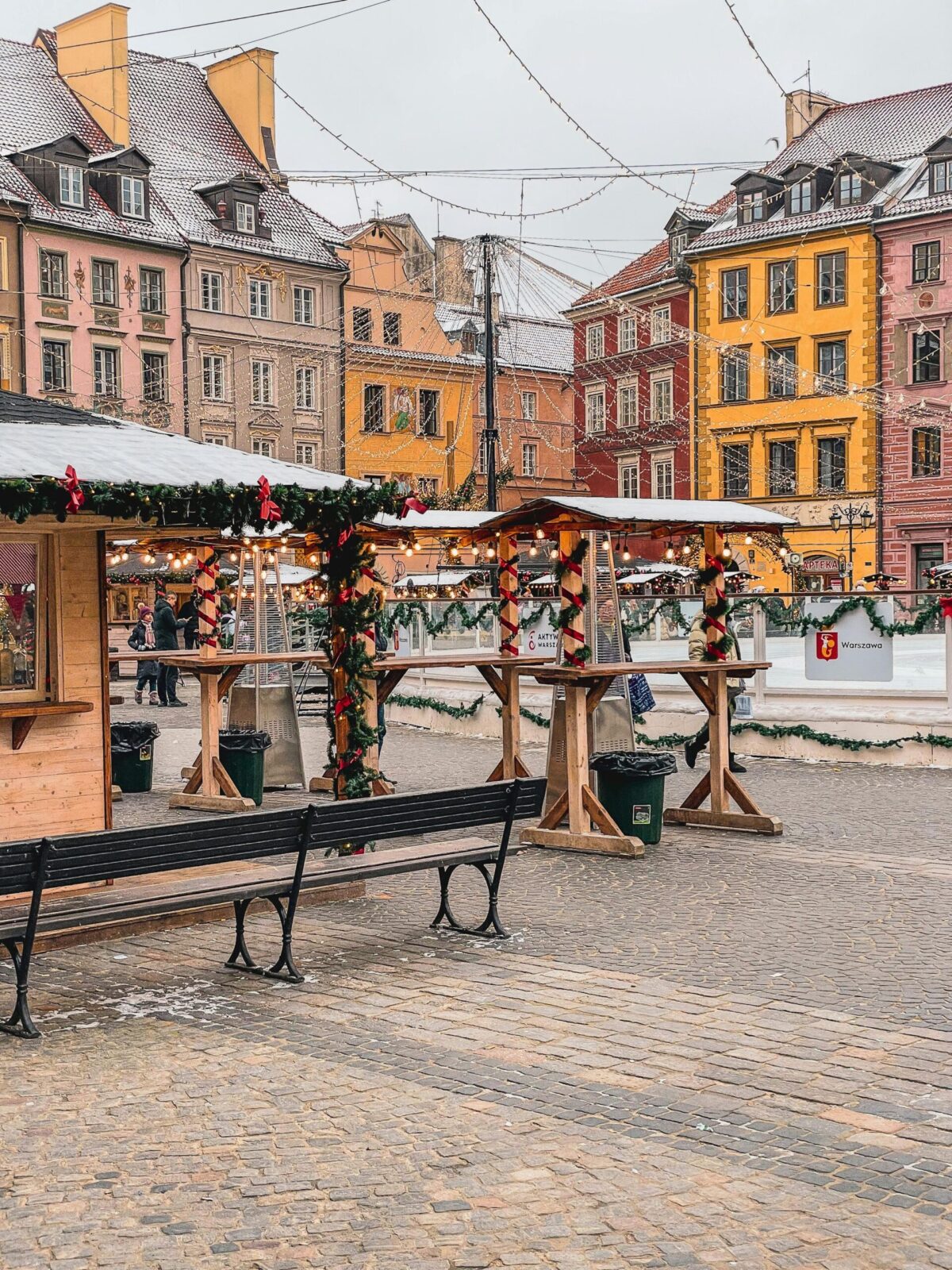 Charming view of Warsaw's festive Christmas market in winter with colorful historical buildings.